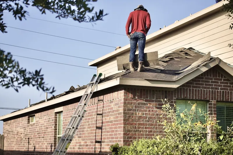 Professional roofer working on a residential roof in Riding Woods